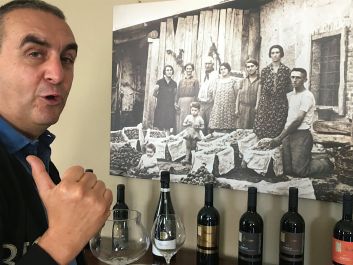 Marco Parusso with a photograph of his family from 1930. The young child standing is Marco’s father and winery namesake Armando Parusso.                                                                (Robert Camuto)